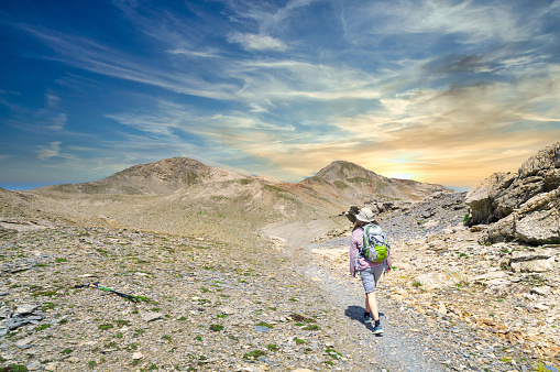 A woman hiker alone on a high mountain trail