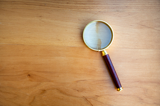 Magnifying glass on wooden desktop