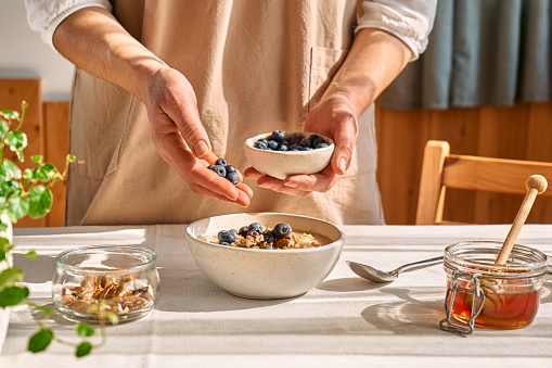 Two hands holding freshly picked European blueberries, picked directly from the forest ground. Trysil, Norway.