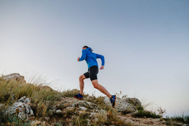 istock male runner running uphill in blue sky background 1470674491