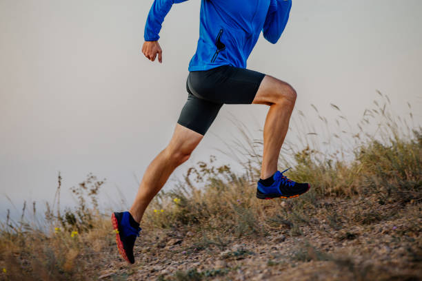 gambe corridore maschile che corre sul sentiero di montagna - cross country running track and field sports event running foto e immagini stock