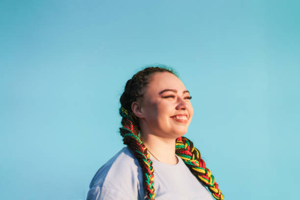Lead yourself to a life of joy. Young Maori woman looking away in front of light blue background in Auckland, New Zealand. maori weaving stock pictures, royalty-free photos & images