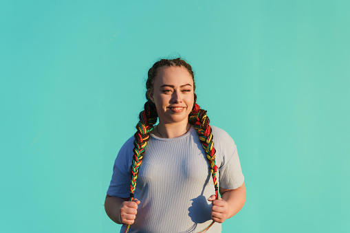 Young Maori woman in front of light green background in Auckland, New Zealand.