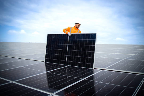 istock Installing solar power plant as sustainable energy source. Worker placing solar panel on the roof. 1470677799