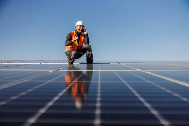 istock A happy worker is crouching next to the solar panels and talking on the phone. 1470679212
