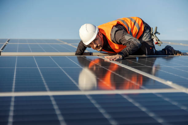 istock A worker is looking at solar panels and checking if they are straight. 1470680003