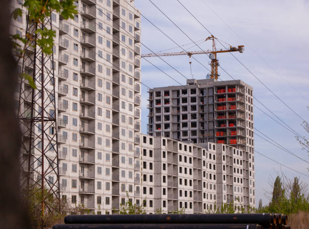 строительство нового панельного высотного здания. модульный дом быстрого строительства. подъемный кран. многоэтажный дом. предыстория стр - modular стоковые фото и изображения