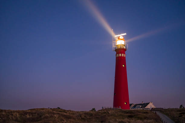 faro en la isla schiermonnikoog en las dunas durante la puesta de sol - lighthouse beacon north sea coastal feature fotografías e imágenes de stock