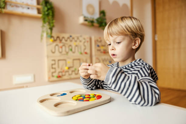 istock A focused little boy is looking at montessori educational toy and learning colors. 1470682047
