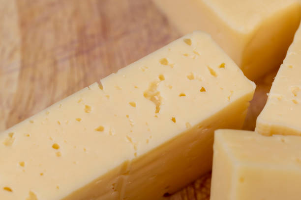 istock Hard cheese with holes cut into thick pieces on a cutting board 1470683310