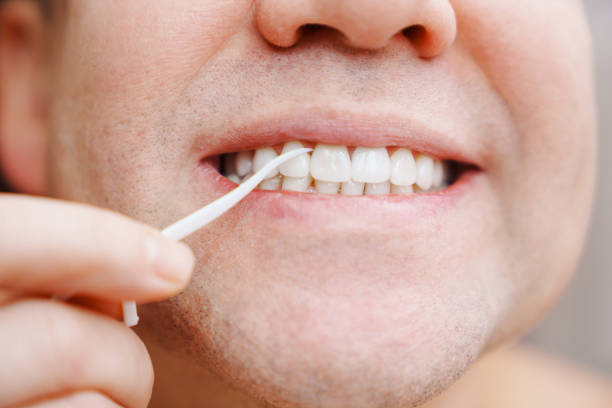 istock close-up a man brush your teeth plastic toothpick with dental floss. 1470684022