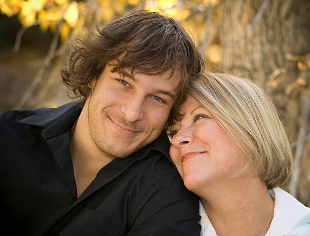 Portrait of a mother and her son. Mom is looking at her son, he's smiling at the camera.