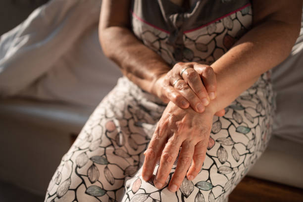 una mujer mayor intenta el automasaje para aliviar el dolor de muñeca - pain joint human hand arthritis fotografías e imágenes de stock