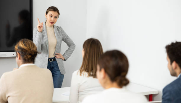 istock Young female tutor teaching students in college classroom 1470691123