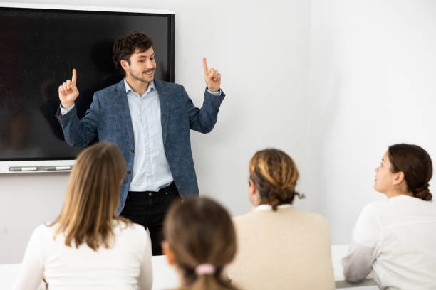 istock Young male tutor teaching students in college classroom 1470691126