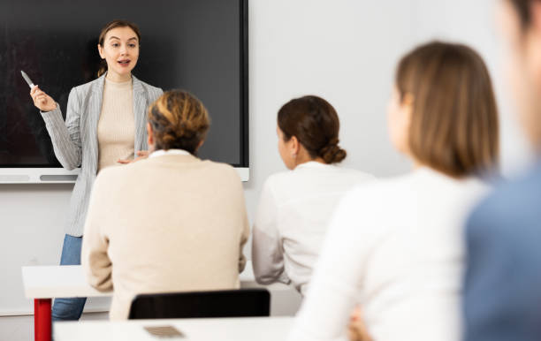 istock Young female tutor teaching students in college classroom 1470691171