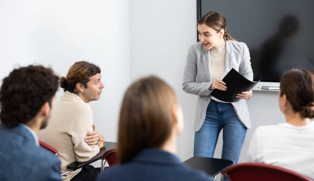 istock Young female professor explaining subject to classroom full of students 1470691195