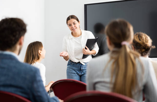 istock Young female professor explaining subject to classroom full of students 1470691218