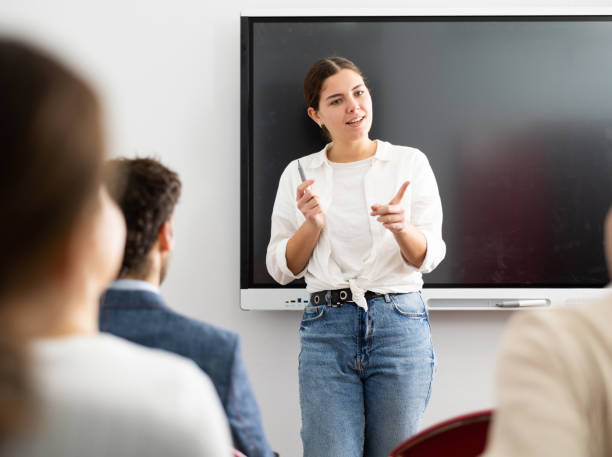 istock Young female tutor teaching students in college classroom 1470691246