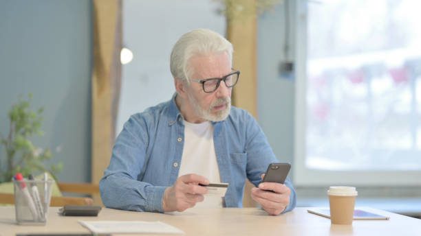 istock Old Man Talking on Phone in Office 1470691581