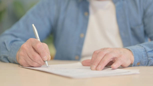 istock Close up of Old Man Writing in Office 1470691939