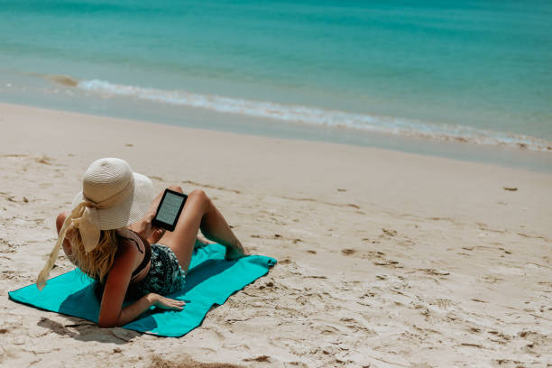 istock Woman Relaxing at Beach on Chair with Electronic Book Reader 1470692001