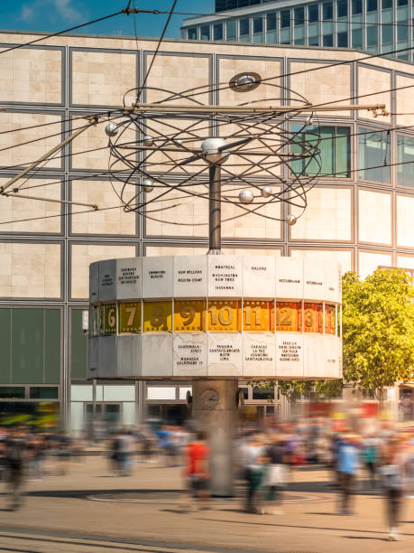 istock Famous world clock at Alexanderplatz, Berlin, Germany, with people walking in front, long exposure, during sunset, vertical shot 1470692018