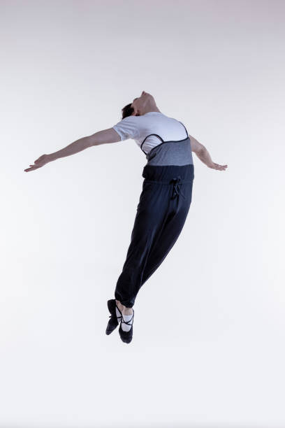 istock Ballet Dancer Performing in Flight With Hands Outspread in Studio Over White Background. 1470692090