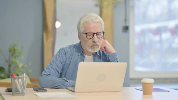 istock Old Man Typing on Laptop in Office 1470693025