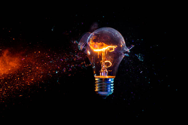 istock Struck electric bulb breaks into fragments, tungsten filament lit 1470693306