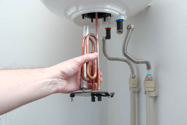 reparação e manutenção de caldeiras. mão do homem colocando um novo aquecedor de água em uma caldeira. - heating element - fotografias e filmes do acervo