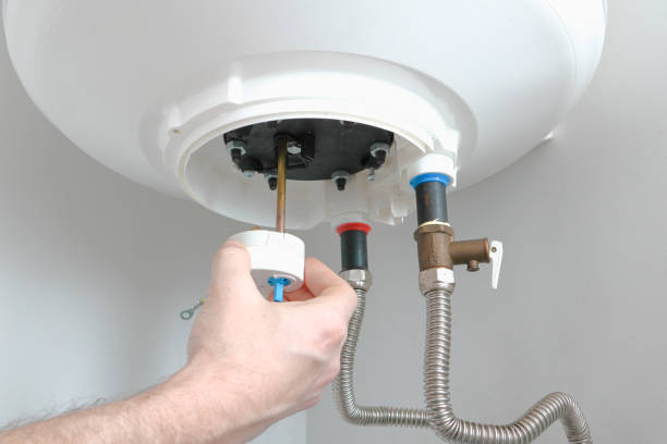 ボイラーの修理とメンテナンス。配管工の手は、修理後にボイラーにサーモスタットを取り付けます。給湯器の修理。 - plumber thermostat repairing engineer ストックフォトと画像