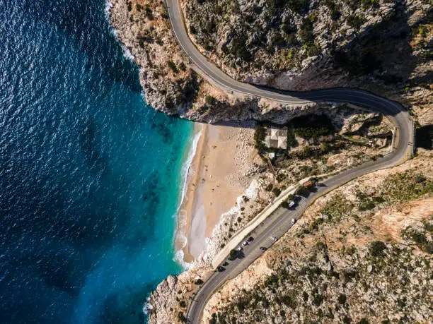 Winding road and sandy beach in the mountains. Drone point of view. Shoot directly above. Kaputas beach