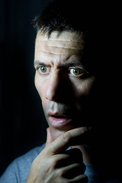 istock wondering man face at dark room 147069487