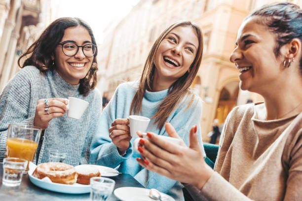 tre giovani donne che si godono la colazione bevendo caffè seduti alla caffetteria del bar - concetto di stile di vita con amiche che si aggirano sulla strada della città - cibo, bevande e concetto di amicizia - coffee couple italy drinking foto e immagini stock