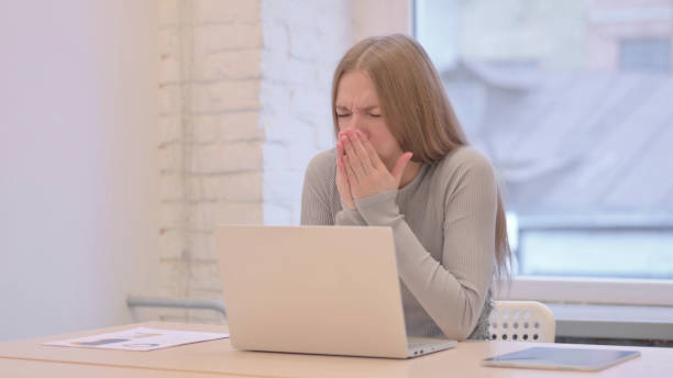 istock Coughing Sick Young Woman Working on Laptop 1470694936