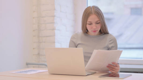 istock Young Woman Working on Laptop and Documents 1470695225