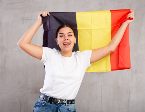 istock Smiling young woman holding Belgium flag 1470695415