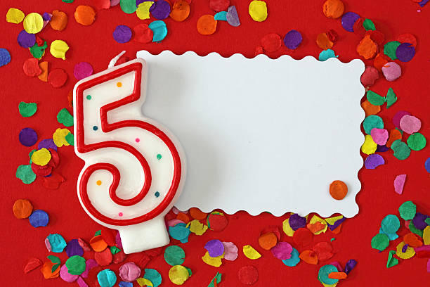 istock Number five birthday candle on red background with confetti 147069543