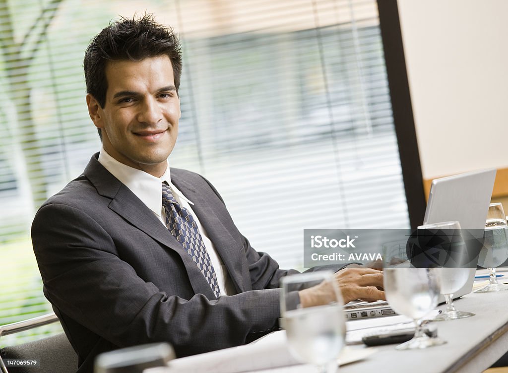 Lächelnd Geschäftsmann sitzt am Tisch mit Laptop - Lizenzfrei Anzug Stock-Foto