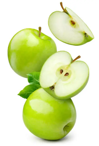 Photo of Green apple isolated. Whole, half and apple slice flying on white background. Green apples with leaves are falling. Full depth of field.