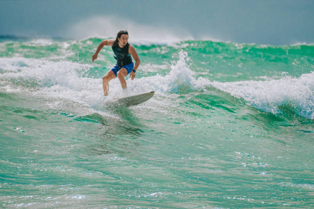istock Asian Chinese Male Surfer riding wave in Pacific Ocean 1470696919