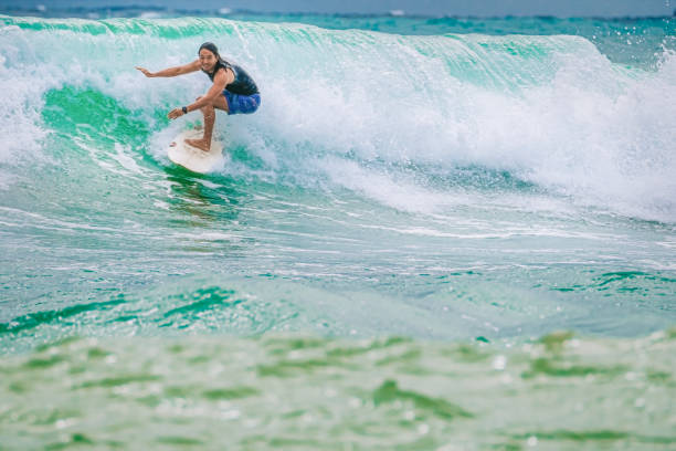 istock Asian Chinese Male Surfer riding wave in Pacific Ocean 1470696982