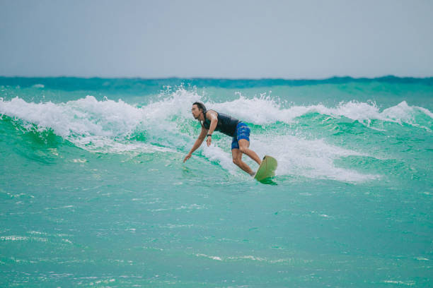 istock Asian Chinese Male Surfer riding wave in Pacific Ocean 1470697054