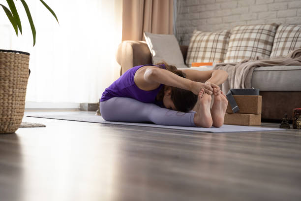 istock Young woman practicing yoga at home 1470698305