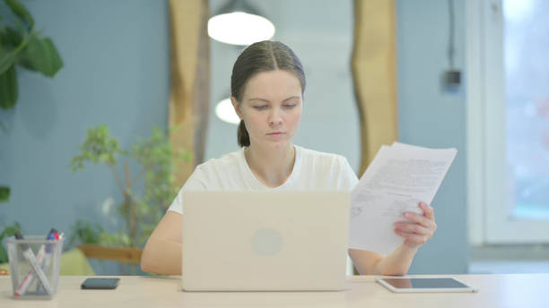 istock Casual Young Woman Working on Laptop and Documents 1470698398