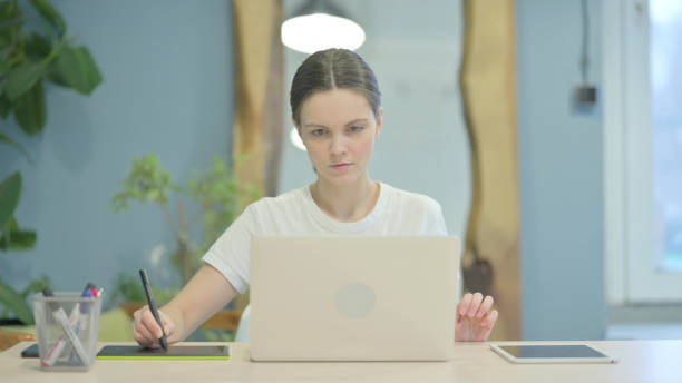 istock Female Designer Working on Laptop and Graphic Tablet 1470698454