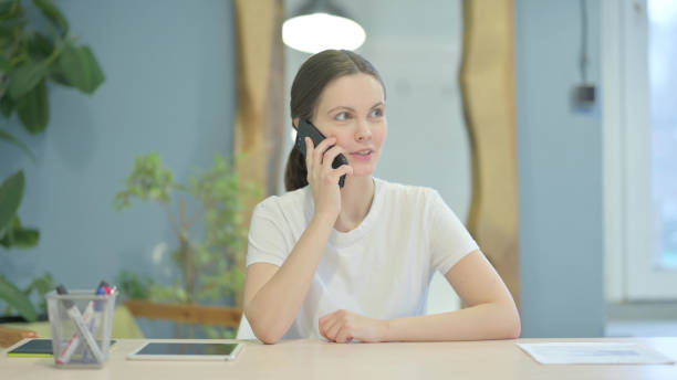 istock Busy Young Woman Talking on Phone at Work 1470698551