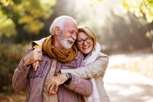 portret pięknej pary seniorów w parku publicznym. wcześniejsza emerytura - senior adult retirement mature adult couple zdjęcia i obrazy z banku zdjęć