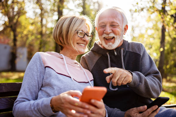 istock Cheerful elderly couple using banking apps on a smartphone to make payments outdoors in the park 1470699993